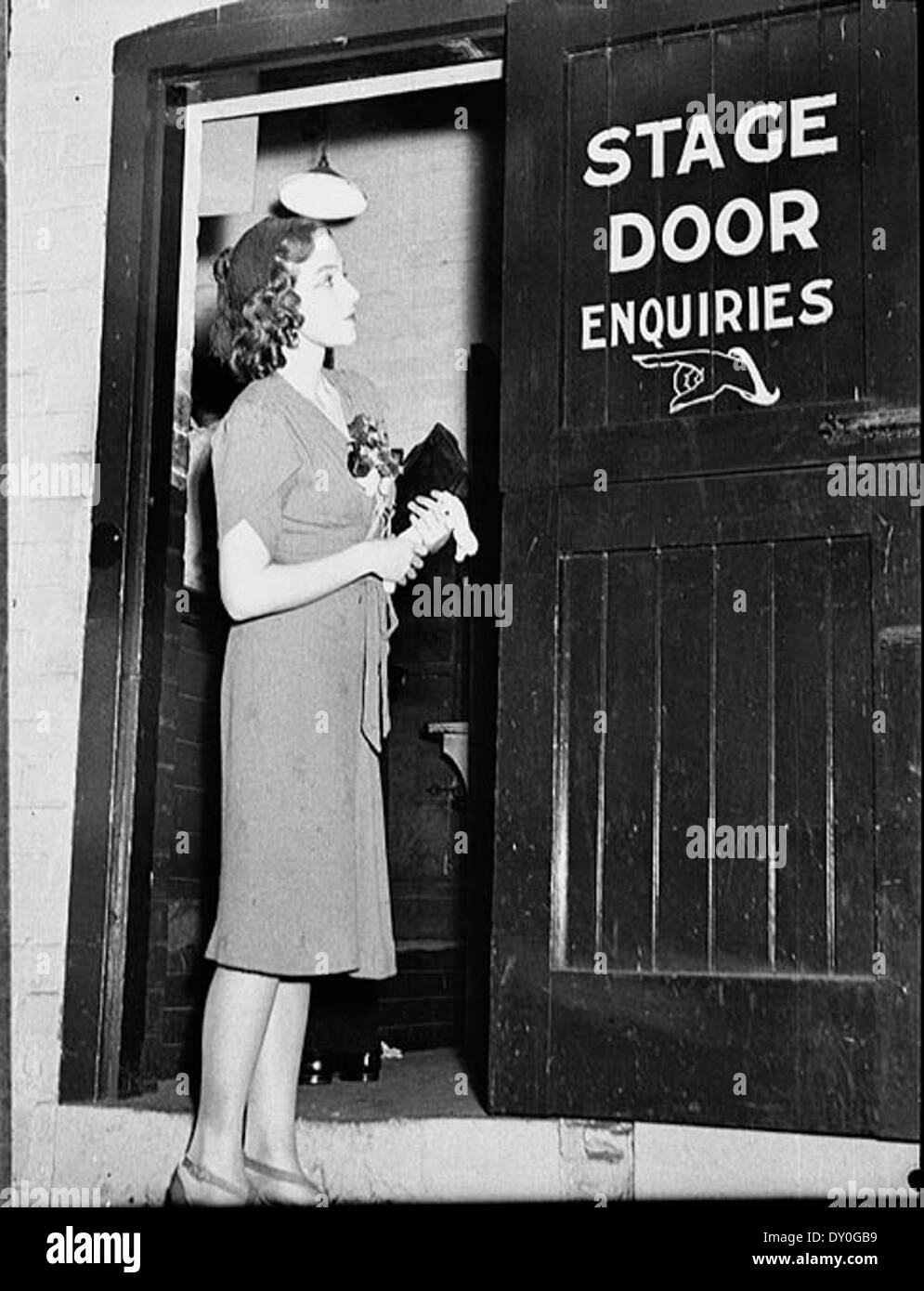 Intrattenitore legge il 'Stage indagini porta' firmare in un teatro JCW, Sydney, 1938 / dal cofano Sam Foto Stock
