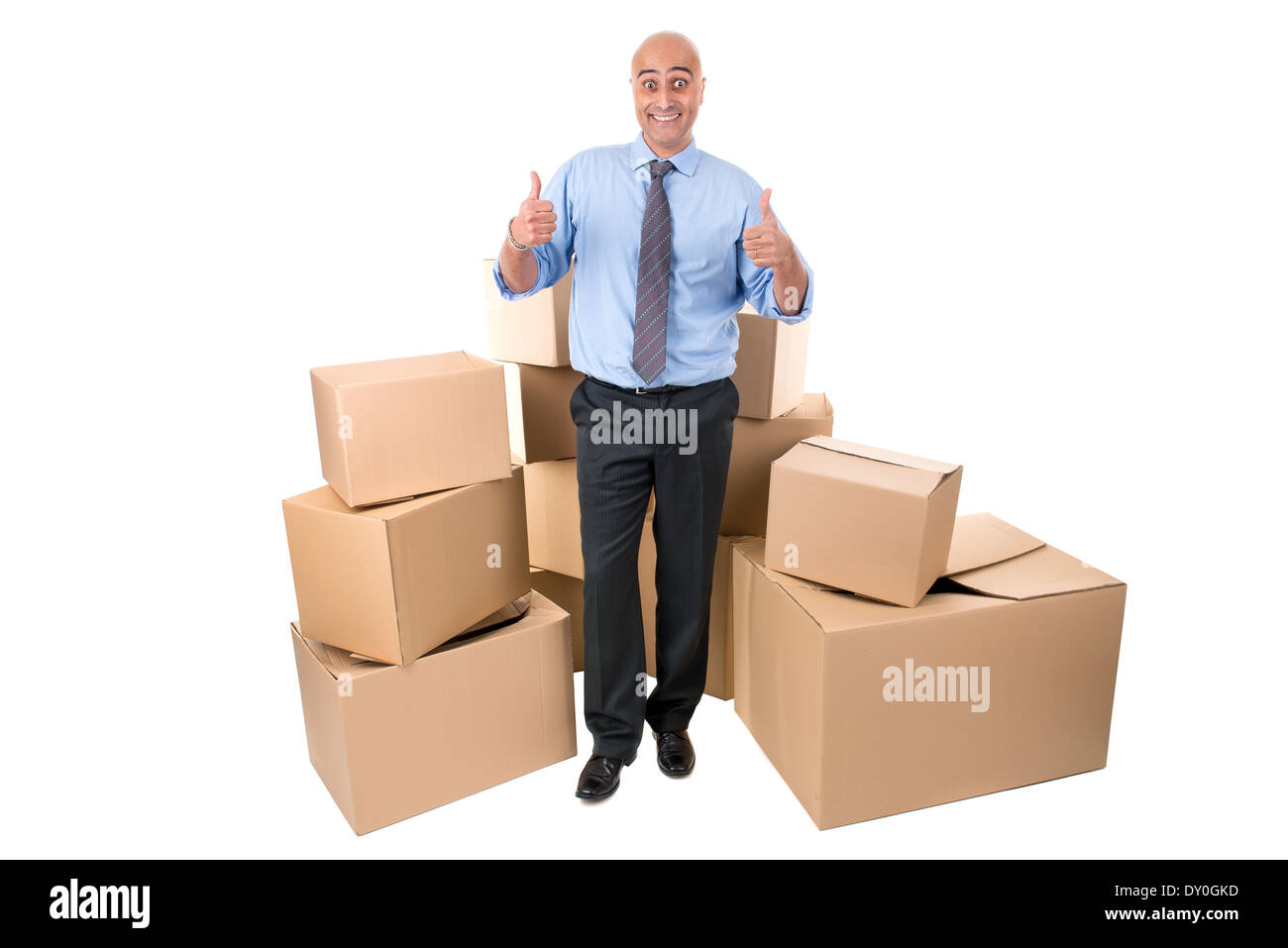 Imprenditore in posa in prossimità di una pila di scatole di cartone Foto Stock