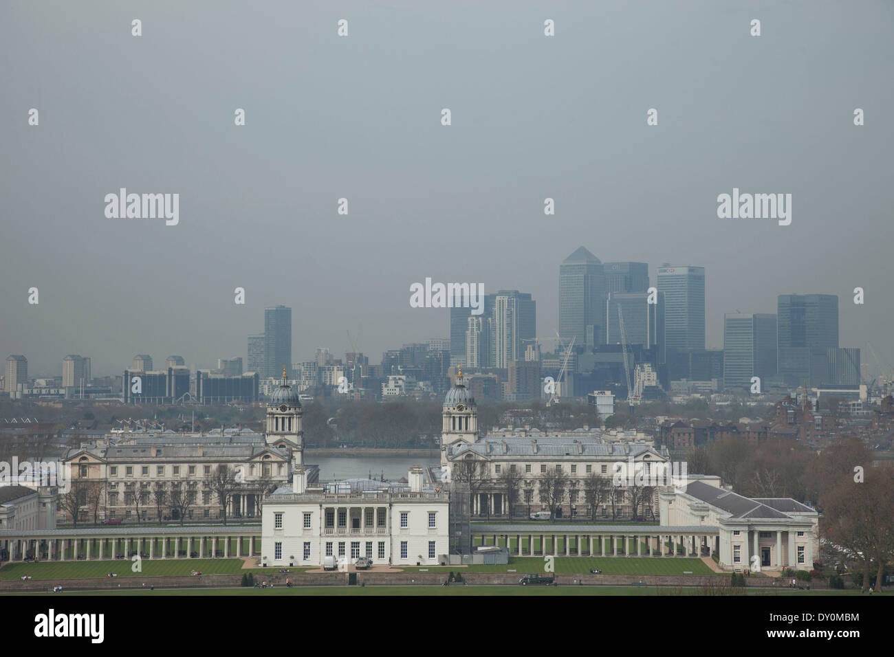 Londra, Regno Unito. Il 2 aprile 2014. Inquinamento industriale in Europa e la polvere del Sahara regione crea uno strato di smog sopra la città di Londra. Appena visibile attraverso l'aria inquinata, gli edifici sembrano scomparire in una scarsa qualità dell'aria. Vista dal parco di Greenwich verso lo skyline di Canary Wharf distretto finanziario attraverso Greenwich Maritime Museum. Credito: Michael Kemp/Alamy Live News Foto Stock