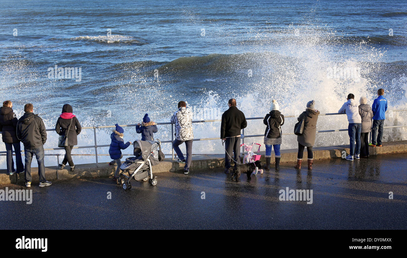 La gente guarda le onde della pastella riva di Aberdeen, Scozia, Regno Unito Foto Stock