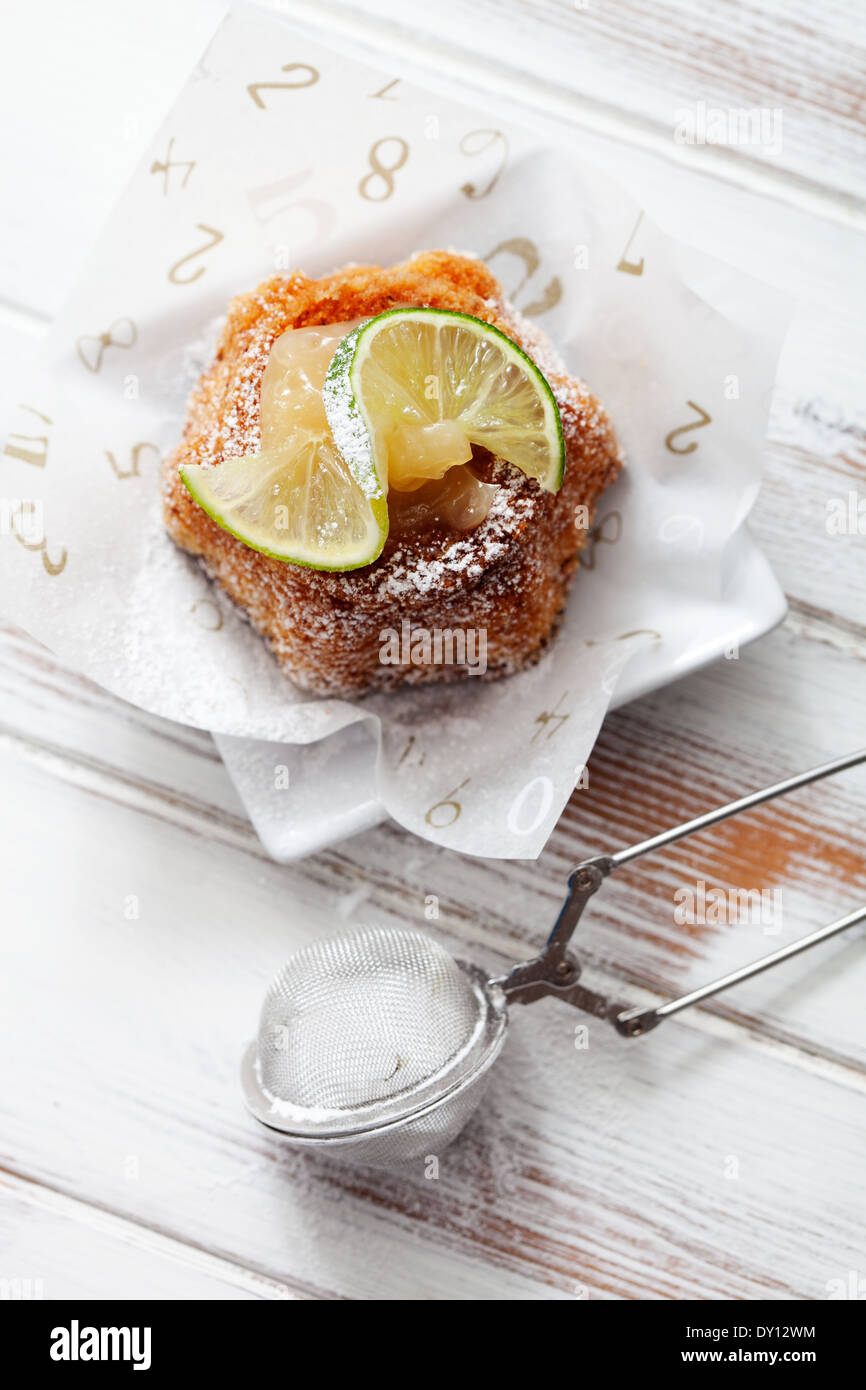 Bundt torta al limone cagliata e fettine di lime Foto Stock