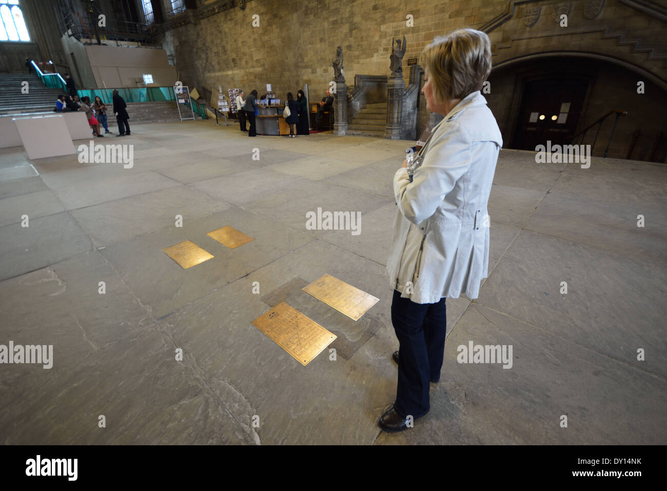 Una donna lettura targhe commemorative nel pavimento di Westminster Hall di Londra, Regno Unito Foto Stock