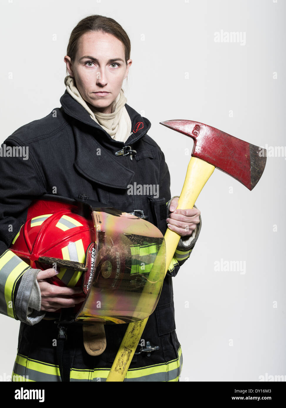 Firefighter femmina in estinzione strutturali uniforme con apparato di respirazione e ax Foto Stock