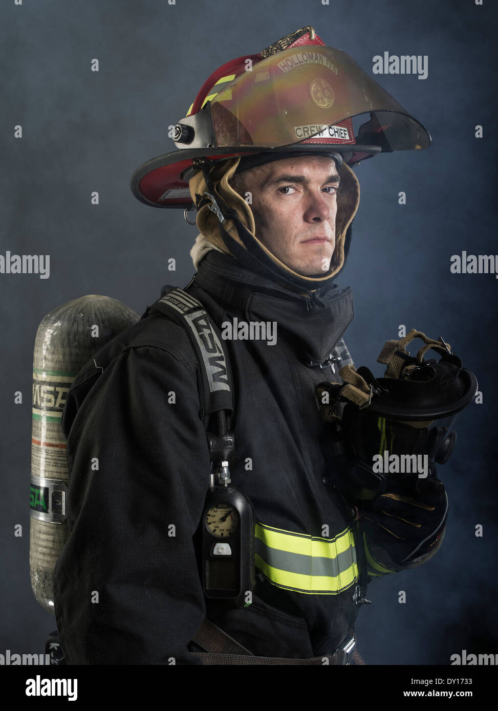 Firefighter maschio in estinzione strutturali uniforme con apparato di respirazione e ax Foto Stock