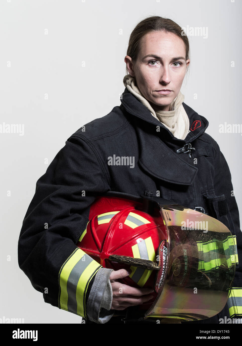 Firefighter femmina in estinzione strutturali uniforme con apparato di respirazione e ax Foto Stock