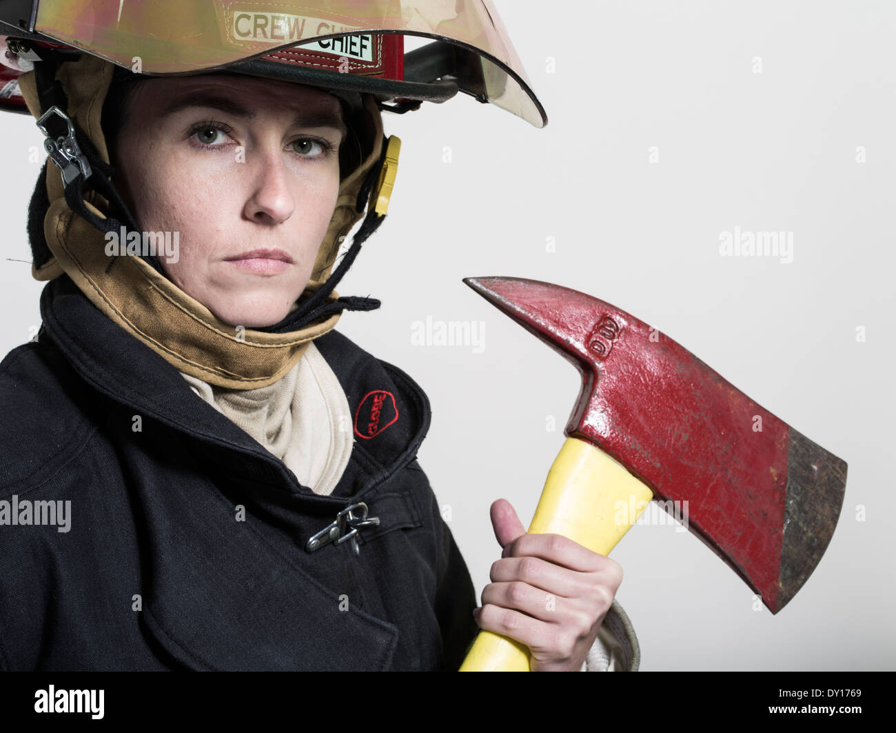 Firefighter femmina in estinzione strutturali uniforme con apparato di respirazione e ax Foto Stock