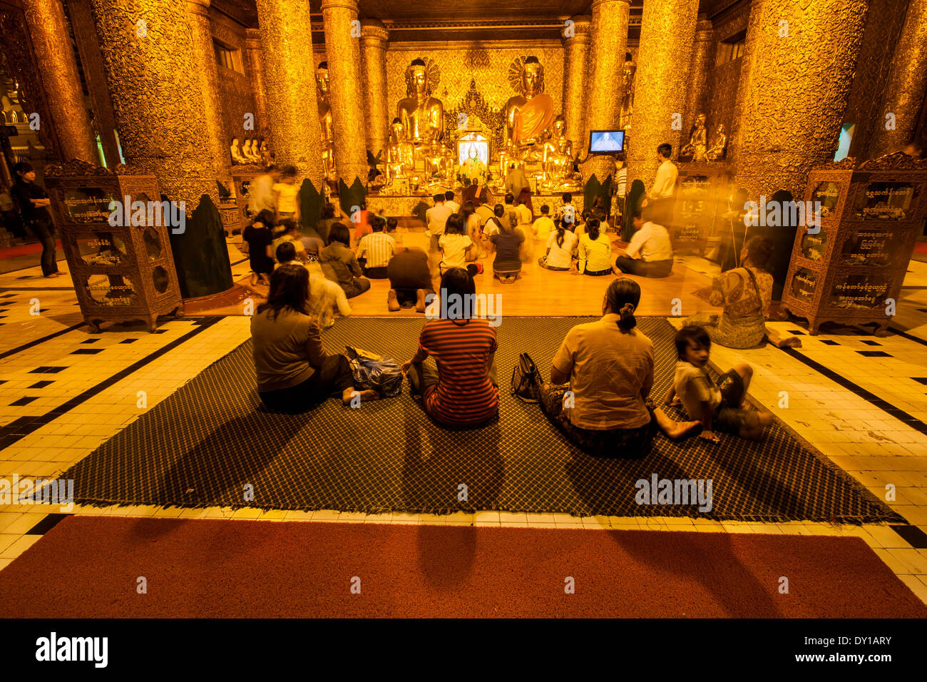 Unidentified popolo birmano seduto di fronte all'immagine del Buddha a Shwedagon Pagada Foto Stock
