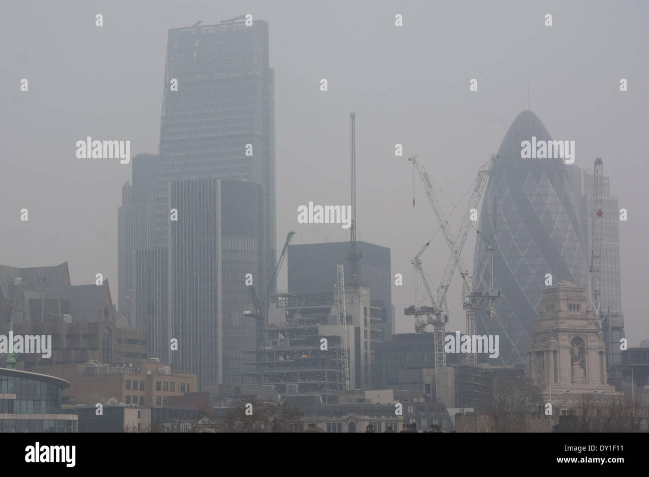 Iconici edifici di Londra come il cetriolino e la dissolvenza Cheesegrater dietro una coltre di inquinamento atmosferico. Foto Stock