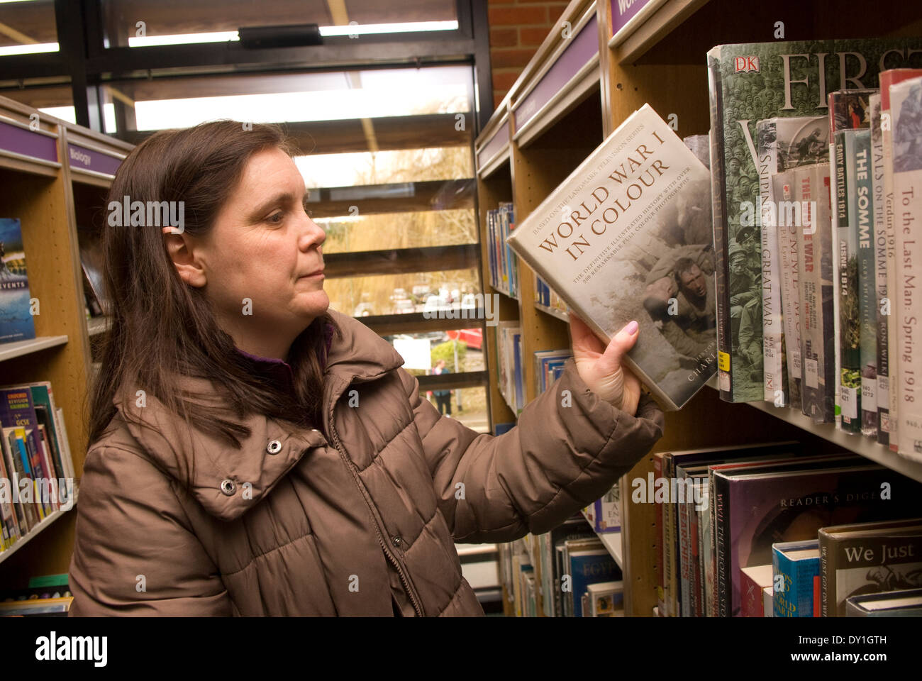 Donna che utilizza la sua libreria locale, Alton, HAMPSHIRE, Regno Unito. Foto Stock