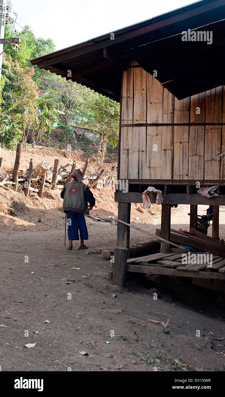 Abitante anziano a piedi con un bastone in un piccolo centro rurale Karen hill tribe village. Huay Pakoot nord della Thailandia. Foto Stock