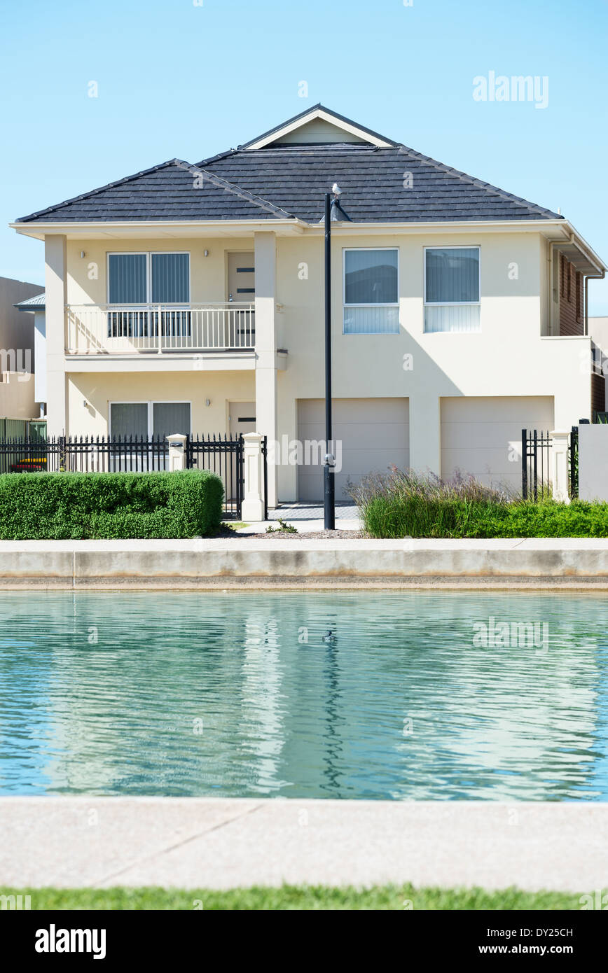 Tipica facciata di una città moderna casa suburbana vicino al laghetto a mezzogiorno Foto Stock