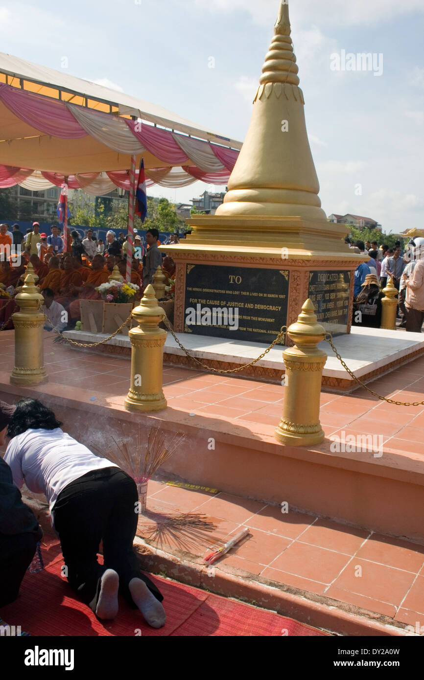 Persone stanno raccogliendo attorno a un memoriale rilevando i nomi delle vittime di un attacco granata alla cerimonia di premiazione a Phom Penh Cambogia. Foto Stock