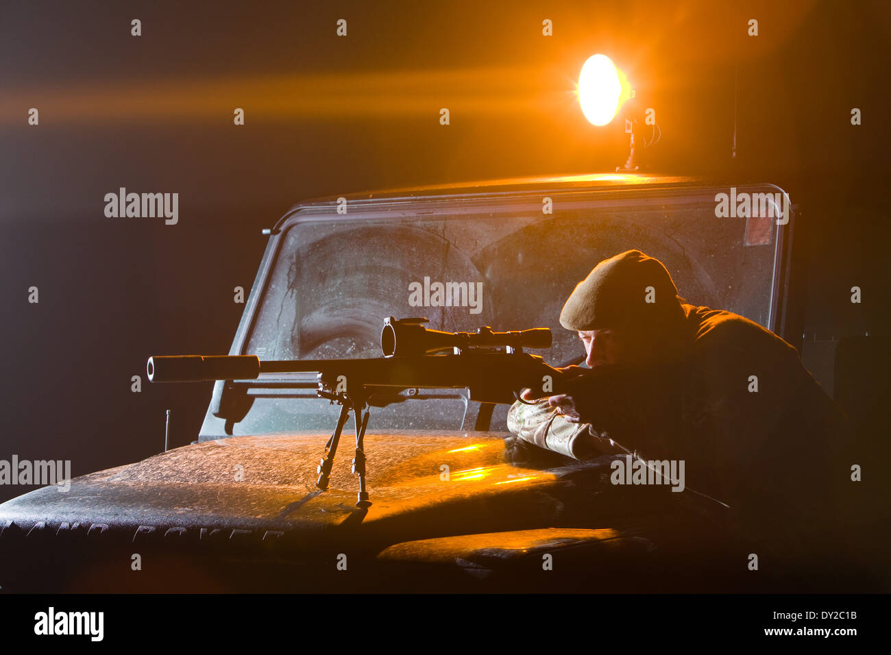 Un gioco Keeper pesti di ripresa di notte da un Land Rover veicolo servendosi di una lampada e un fucile Foto Stock