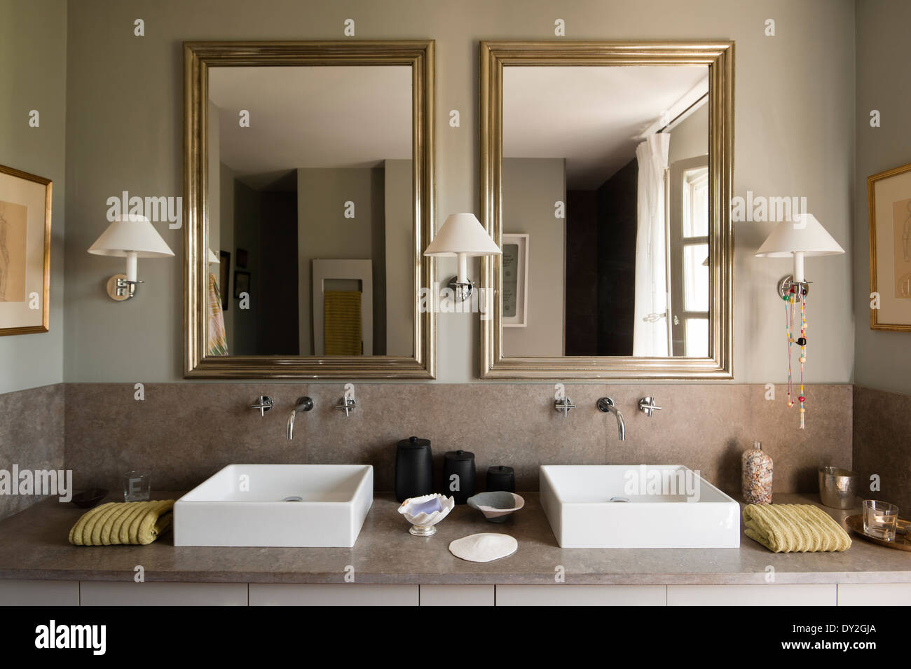 Gemellata moderna bacini di quadri e specchi in bagno in toni di grigio. La parete è di vernice da Emery & Cie Foto Stock