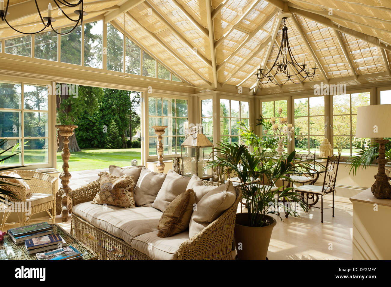 Ampia veranda con mobili di canna e coppia di lampadari in ferro tutte da Marston Langinger e. Foto Stock