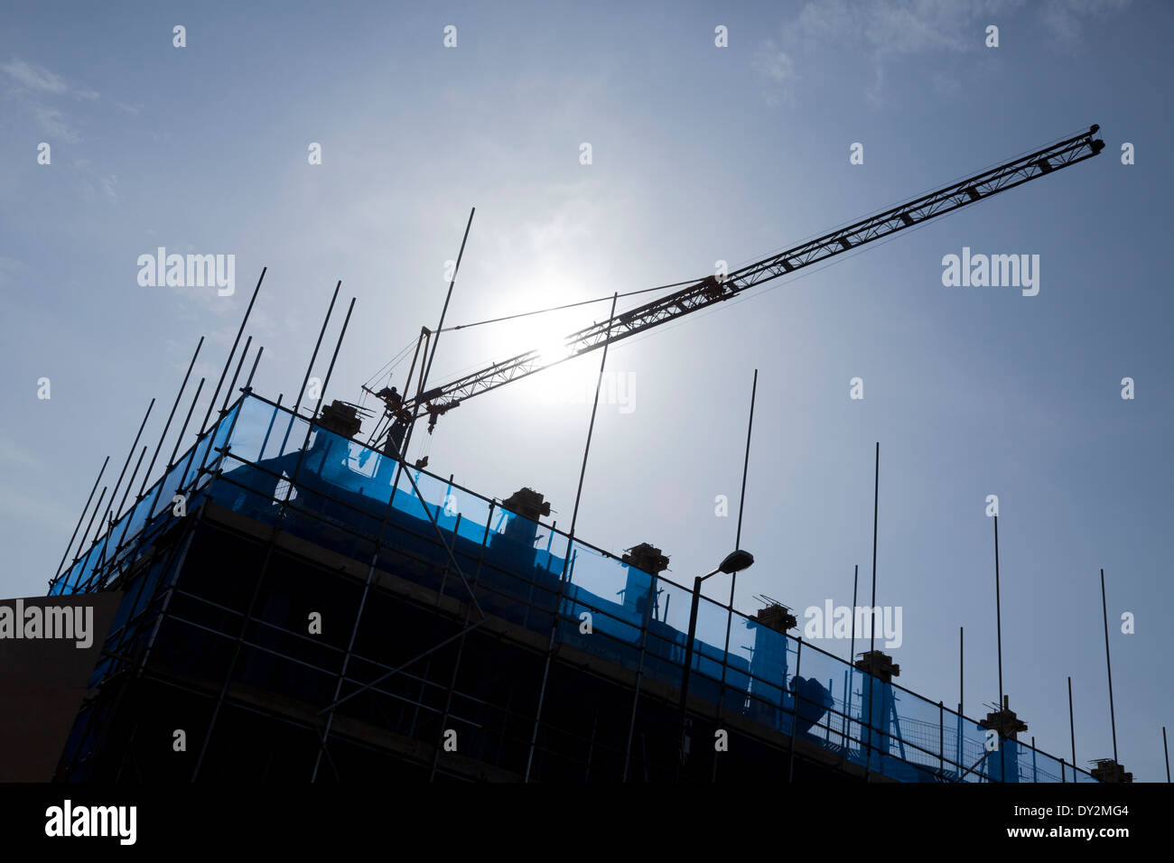 Gru di cantiere e ponteggio contro sun. Foto Stock