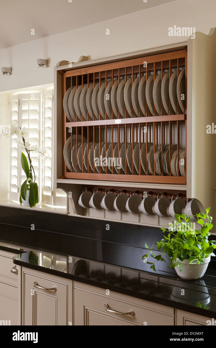 Piastra in legno stendino al di sopra di un granito nero del piano di lavoro con la pianta di basilico Foto Stock