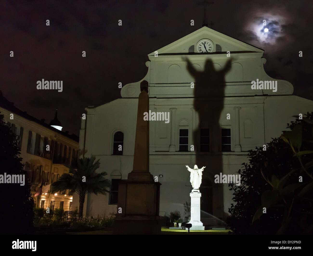 La luna piena sorge su di Sant'Antonio giardino con un'ombra dalla statua di Gesù nel Quartiere Francese di New Orleans, LA Foto Stock