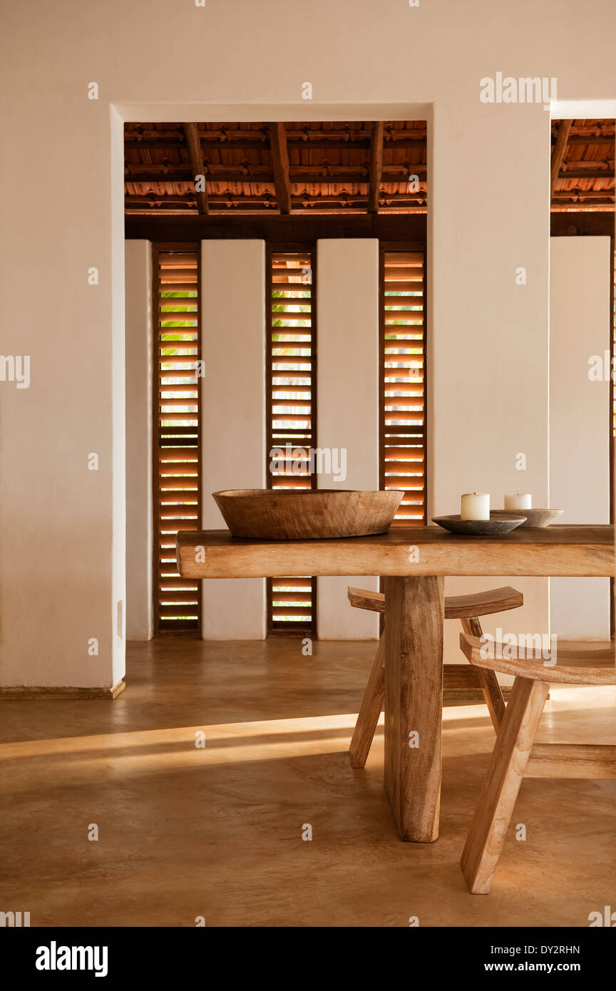 In legno intagliato tavolini e sgabelli con persiane in beach house retreat, lo stato indiano di Goa Foto Stock