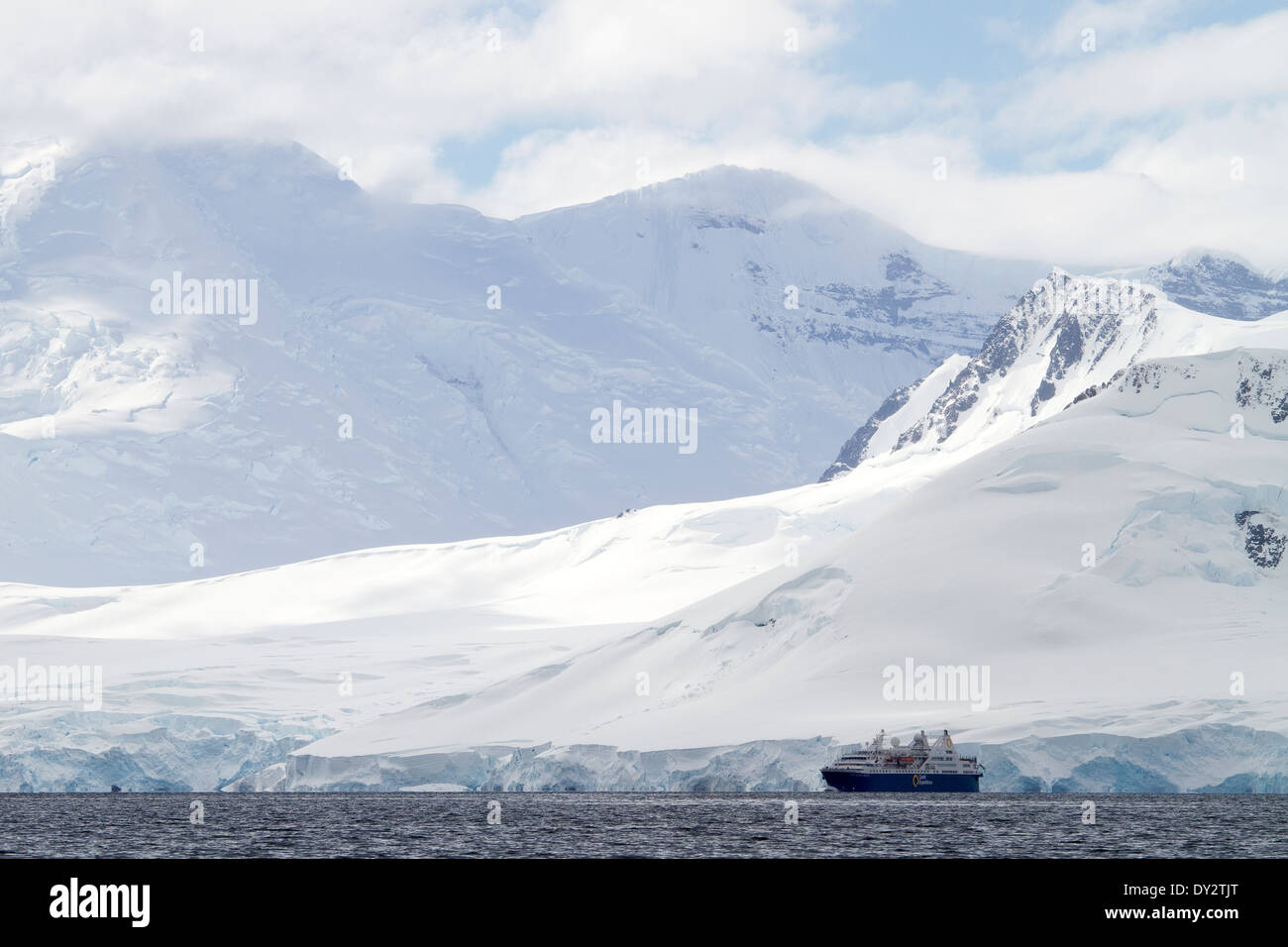 L'Antartide turismo expedition cruise ship sembra piccolo in Antartide paesaggio di montagne, montagna, Penisola antartica. Foto Stock