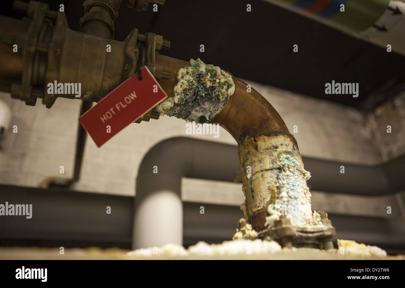Flusso caldo, sali di calcio, deposito di calcare si accumulano su tubi di acqua calda su sistema di riscaldamento domestico di cura, Regno Unito Foto Stock
