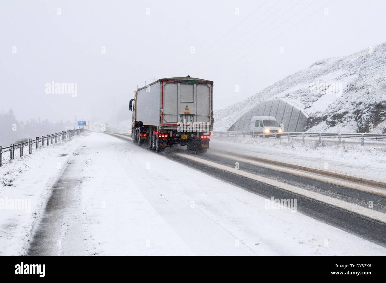 Un camion al vertice della coperta di neve Drumochter passare sulla A9 strada in inverno. Grampian Mountains, Scotland, Regno Unito Foto Stock