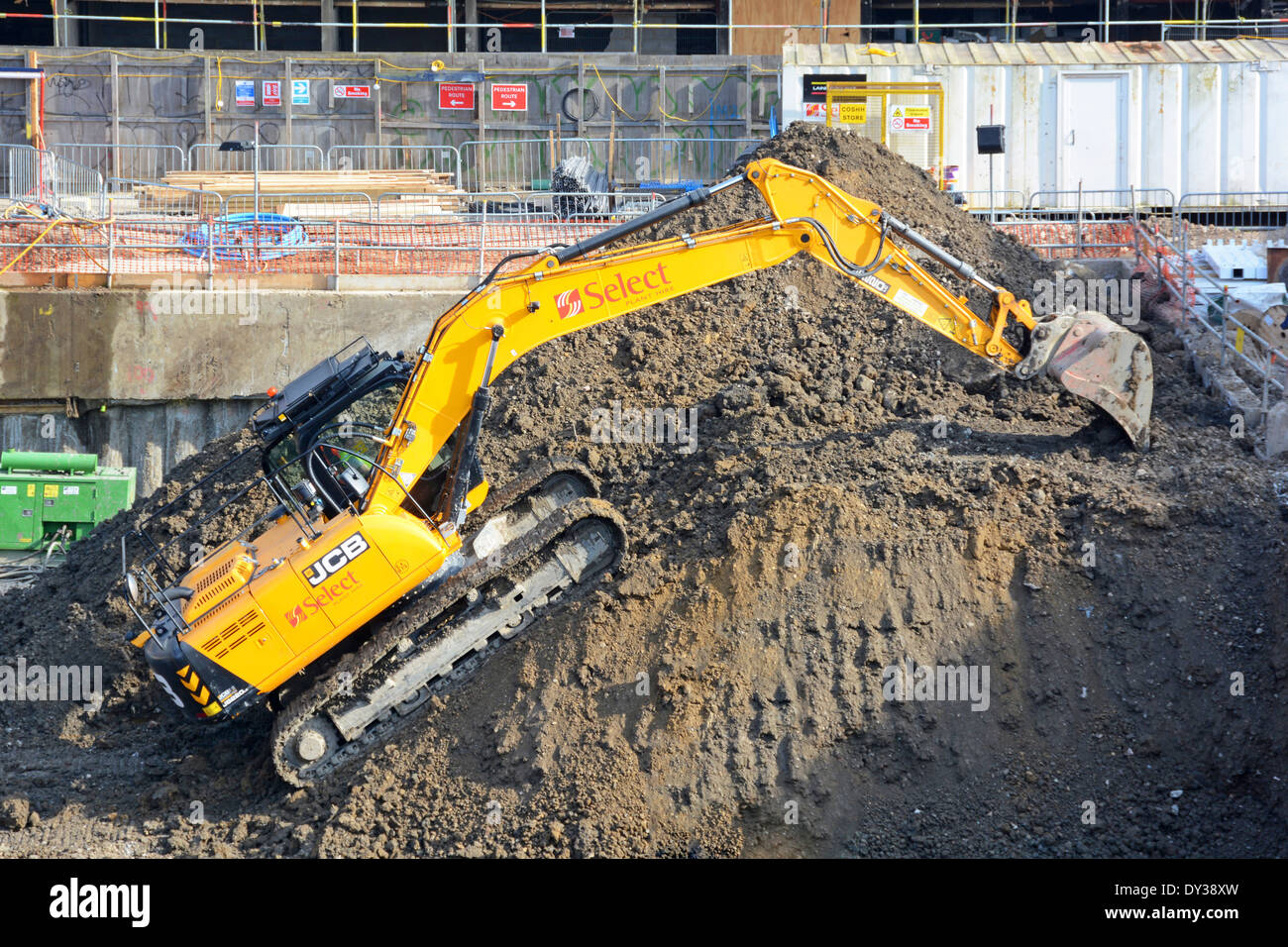 J.C. Bamford JCB attrezzature per escavatori cingolati macchina al lavoro che sale fino alla cima di un cumulo di rovina sul cantiere edile Londra Inghilterra Regno Unito Foto Stock
