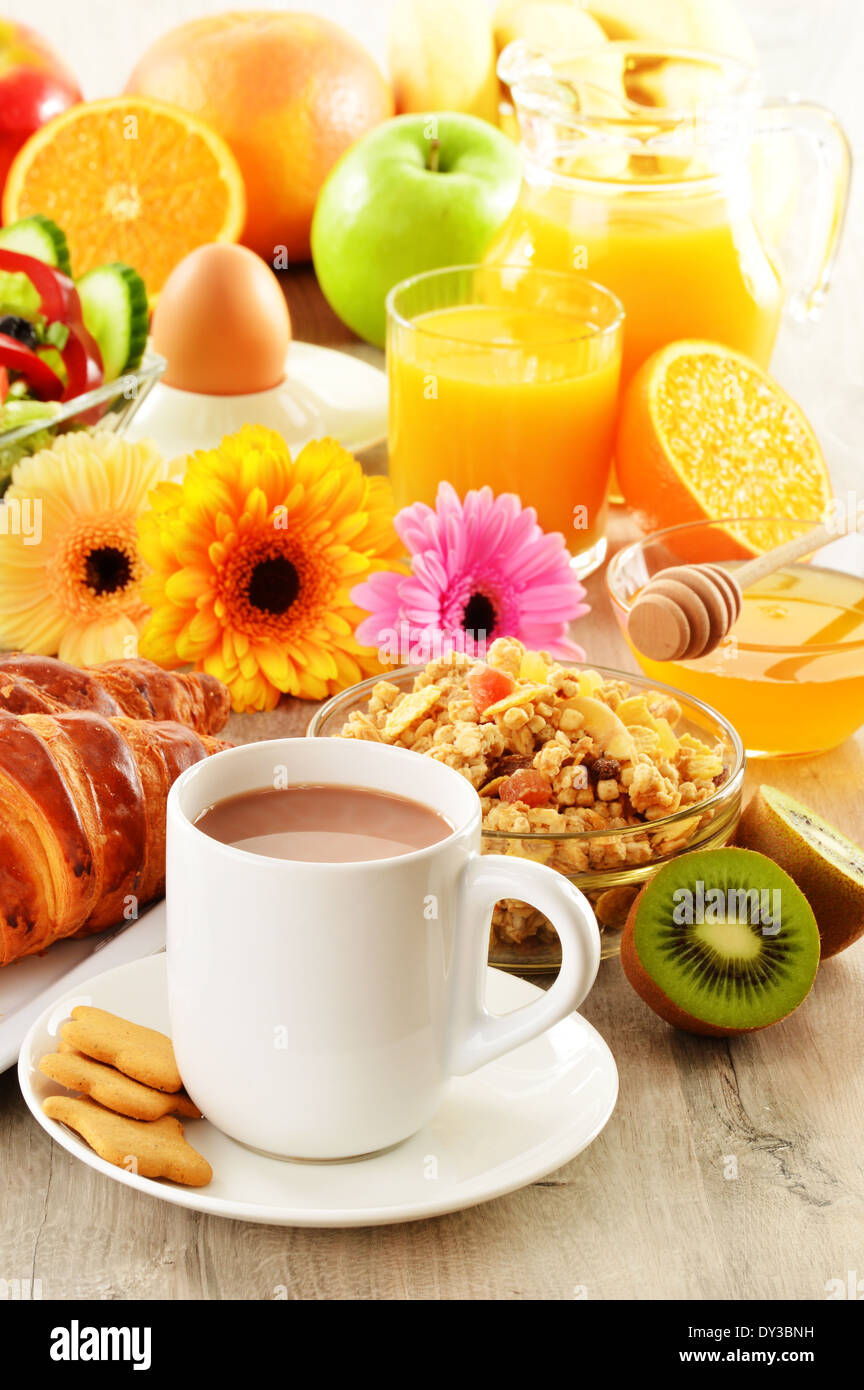 La prima colazione con caffè, succo di frutta, croissant, insalata, muesli e uovo. Buffet svedese Foto Stock