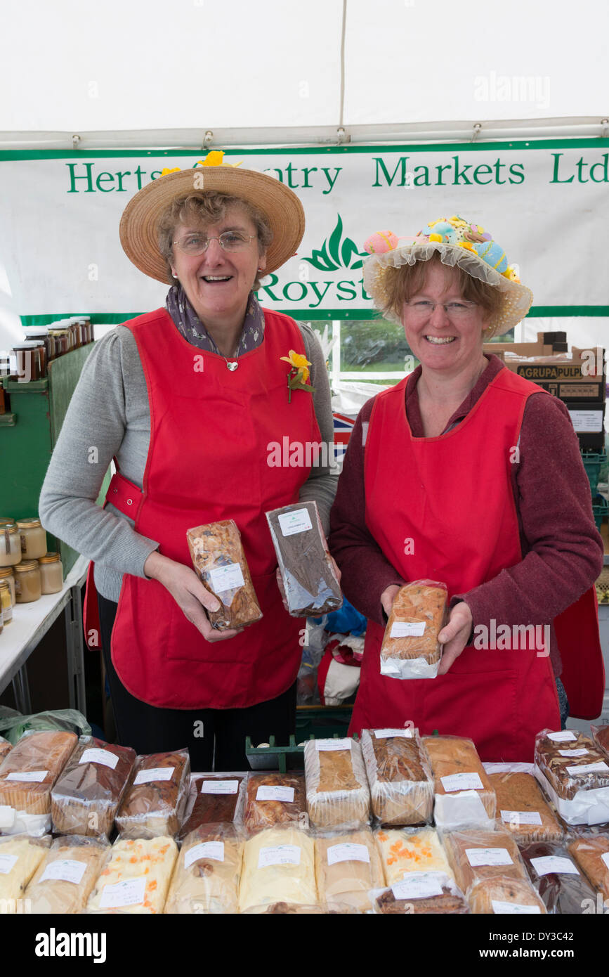 Thriplow, Cambridgeshire, Regno Unito. 5 aprile 2014. Visitatori due stallholders vendere torte fatte in casa come migliaia di persone godono di sole primaverile al Thriplow Daffodil Weekend in Cambridgeshire Regno Unito 5 aprile 2014. Ogni anno tra 7000-10000 persone frequentano il villaggio evento per vedere visualizza dei narcisi, visitando i residenti giardini aperti, craft fienili, chioschi, Morris dancing, paese dimostrazioni di artigianato, pesanti cavalli e fiera del divertimento escursioni. Le strade sono chiuse al traffico consentendo ai visitatori di passeggiare al grazioso villaggio corsie in una celebrazione della primavera. Credito: Julian Eales/Alamy Live News Foto Stock Thriplow, Cambridgeshire, Regno Unito. 5 aprile 2014. Visitatori due stallholders vendere torte fatte in casa come migliaia di persone godono di sole primaverile al Thriplow Daffodil Weekend in Cambridgeshire Regno Unito 5 aprile 2014. Ogni anno tra 7000-10000 persone frequentano il villaggio evento per vedere visualizza dei narcisi, visitando i residenti giardini aperti, craft fienili, chioschi, Morris dancing, paese dimostrazioni di artigianato, pesanti cavalli e fiera del divertimento escursioni. Le strade sono chiuse al traffico consentendo ai visitatori di passeggiare al grazioso villaggio corsie in una celebrazione della primavera. Credito: Julian Eales/Alamy Live News Foto Stock