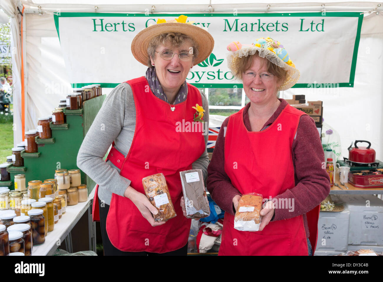 Thriplow, Cambridgeshire, Regno Unito. 5 aprile 2014. Visitatori due stallholders vendere torte fatte in casa come migliaia di persone godono di sole primaverile al Thriplow Daffodil Weekend in Cambridgeshire Regno Unito 5 aprile 2014. Ogni anno tra 7000-10000 persone frequentano il villaggio evento per vedere visualizza dei narcisi, visitando i residenti giardini aperti, craft fienili, chioschi, Morris dancing, paese dimostrazioni di artigianato, pesanti cavalli e fiera del divertimento escursioni. Le strade sono chiuse al traffico consentendo ai visitatori di passeggiare al grazioso villaggio corsie in una celebrazione della primavera. Credito: Julian Eales/Alamy Live News Foto Stock Thriplow, Cambridgeshire, Regno Unito. 5 aprile 2014. Visitatori due stallholders vendere torte fatte in casa come migliaia di persone godono di sole primaverile al Thriplow Daffodil Weekend in Cambridgeshire Regno Unito 5 aprile 2014. Ogni anno tra 7000-10000 persone frequentano il villaggio evento per vedere visualizza dei narcisi, visitando i residenti giardini aperti, craft fienili, chioschi, Morris dancing, paese dimostrazioni di artigianato, pesanti cavalli e fiera del divertimento escursioni. Le strade sono chiuse al traffico consentendo ai visitatori di passeggiare al grazioso villaggio corsie in una celebrazione della primavera. Credito: Julian Eales/Alamy Live News Foto Stock