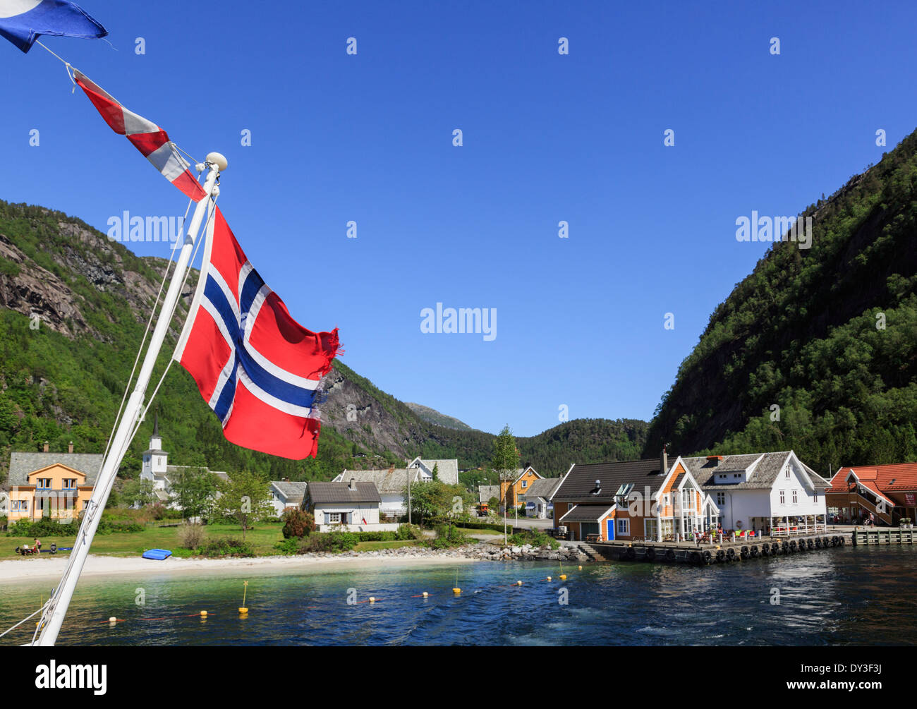 Bandiera della Norvegia sulla gita sulla barca Mofjorden lasciando grazioso villaggio norvegese di Mo, Modalen, Hordaland, Norvegia e Scandinavia Foto Stock