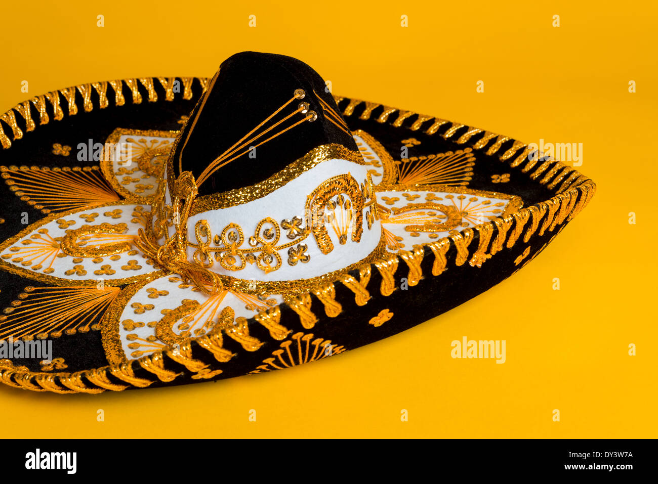 Ornati in nero, oro e bianco del sombrero messicano su un brillante sfondo giallo Foto Stock