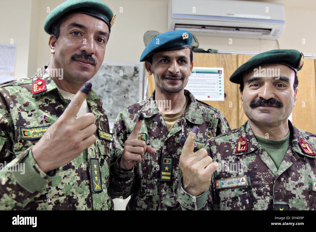 Esercito Nazionale Afghano soldati hanno alzato le loro dita contrassegnati con inchiostro blu che mostra che hanno votato alle elezioni presidenziali di aprile 5, 2014 in avanti una base operativa di gamberi, Laghman provincia, Afghanistan. Foto Stock