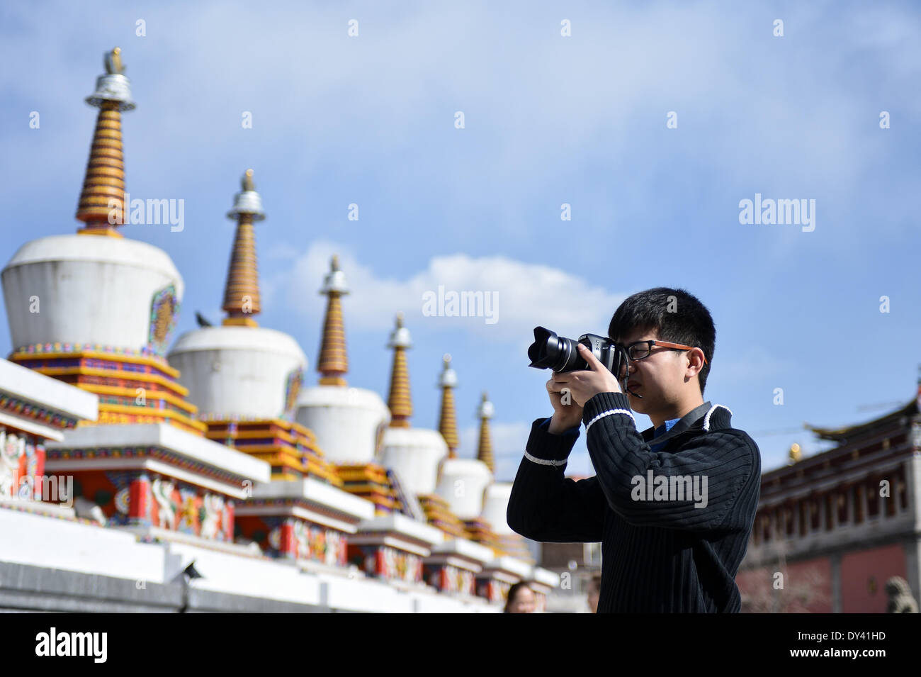 La Contea di Huangzhong, la Cina della Provincia di Qinghai. 6 apr, 2014. Un turista chiamata richiede le foto nel monastero Kumbum Huangzhong nella contea di Xining, capitale della Cina nord-occidentale della Provincia di Qinghai, Aprile 6, 2014. Il monastero di Kumbum è una destinazione principale per il buddista tibetana pellegrini. È anche una delle principali attrazioni turistiche nella vicina Qinghai, che offre splendidi murali religiose, Thangka appliques e sculture di burro. © Wu pista/Xinhua/Alamy Live News Foto Stock