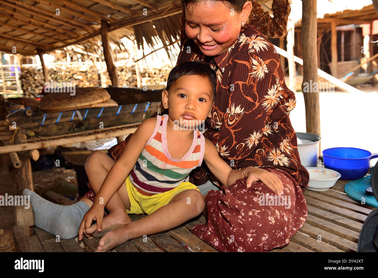 Ritratto studio di nonna e nipote sotto casa di palafitte nel peperoncino cottage industria, Cambogia, Sud-est asiatico Foto Stock