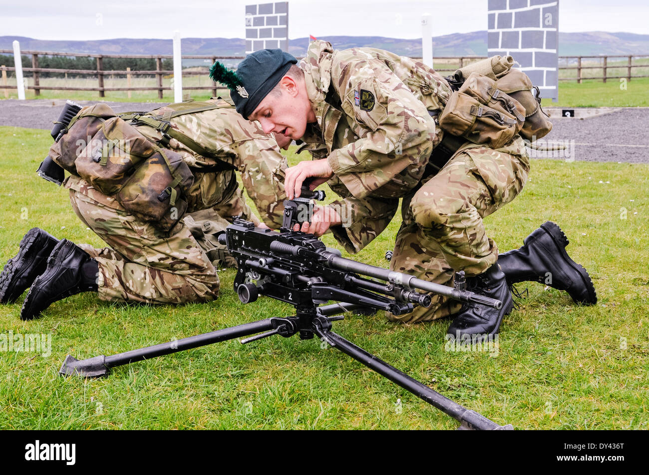 Un soldato dal 2 Batt Royal Irish Regiment attribuisce la vista di una macchina per usi generici pistola (GPMG) Foto Stock