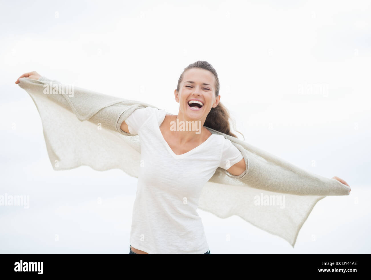 Felice giovane donna sulla spiaggia a freddo gioia Foto Stock