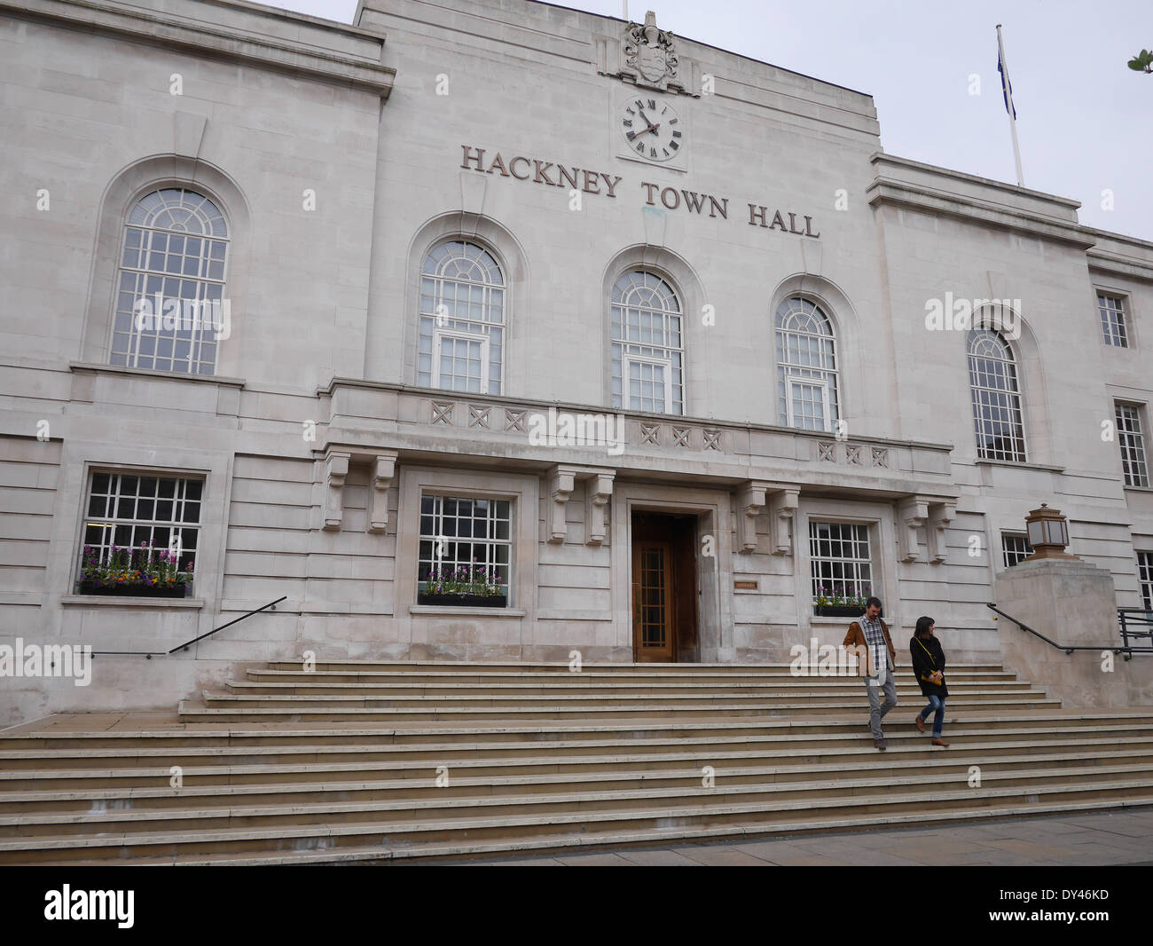 Pedoni che camminano lungo i gradini del municipio di Hackney a Londra, Regno Unito. Attività quotidiane all'esterno dell'edificio civico classificato Grade II nella zona est di Londra Foto Stock