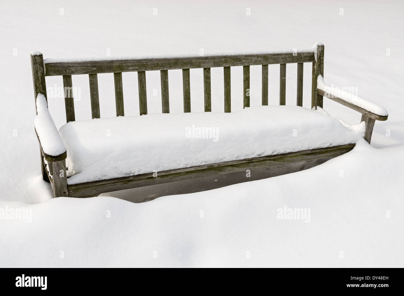Snowy panca in legno coperto in un accumulo di neve in inverno Foto Stock