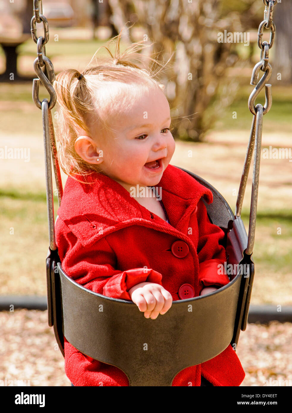 Adorabili, carino 16 mese bambina basculante in un parco giochi per bambini Foto Stock