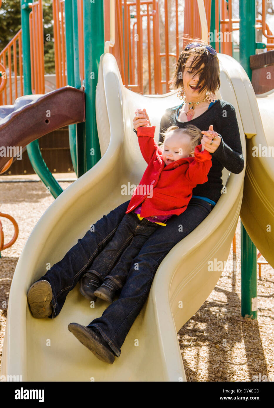 Giovane e bella madre giocando con 16 mese Baby girl su parco giochi per bambini Foto Stock