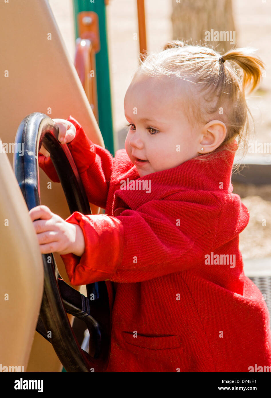 Adorabili, carino 16 mese bambina gioca su un parco giochi per bambini Foto Stock