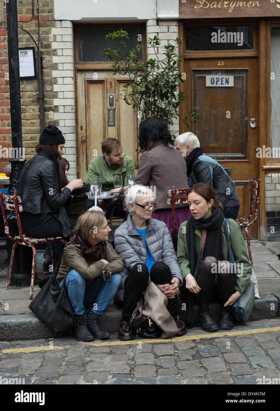 La gente seduta al di fuori del pub, Columbia Road. Londra Foto Stock