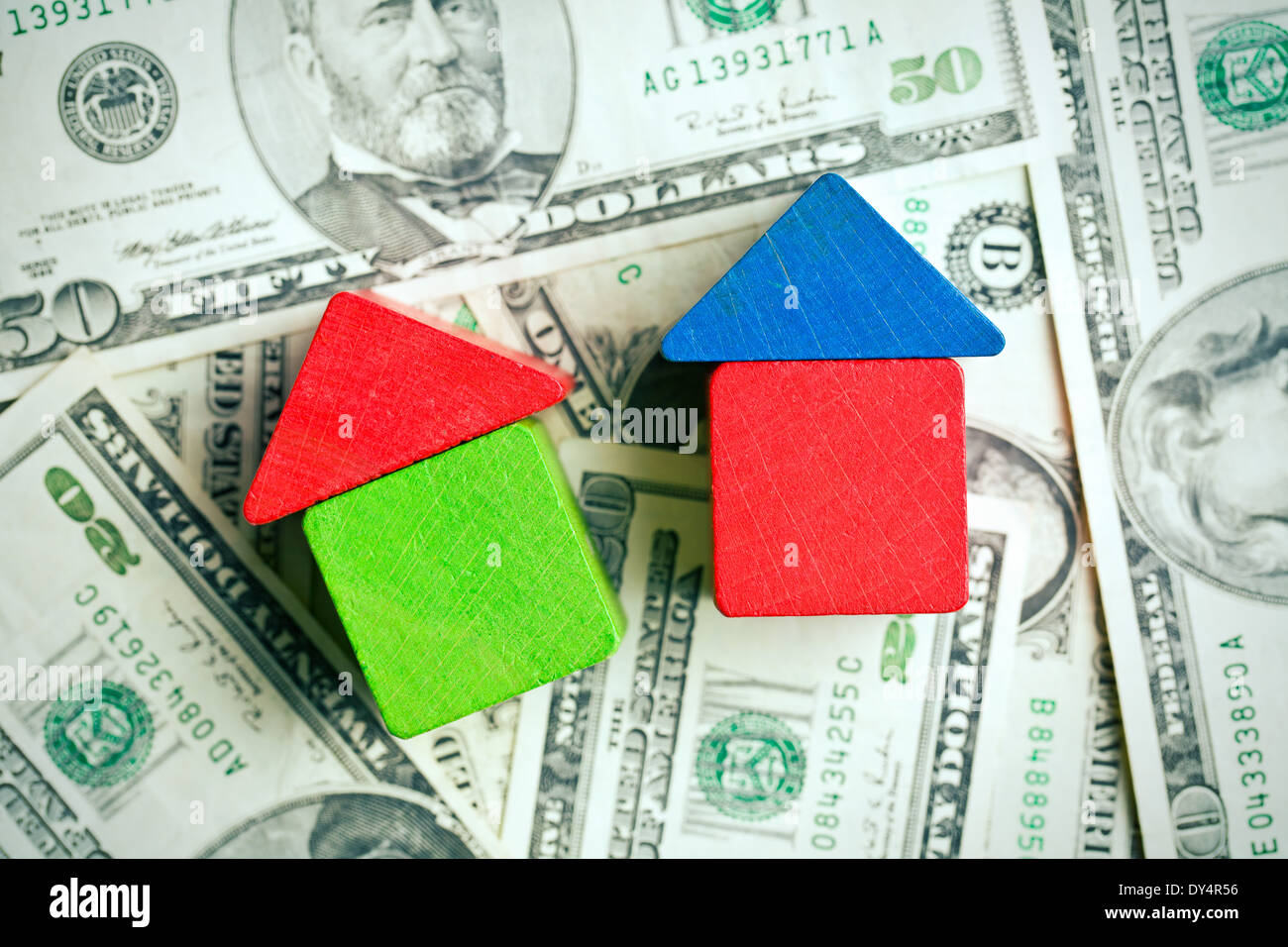 La casa fatta da giocattolo di legno blocchi sul background del dollaro Foto Stock
