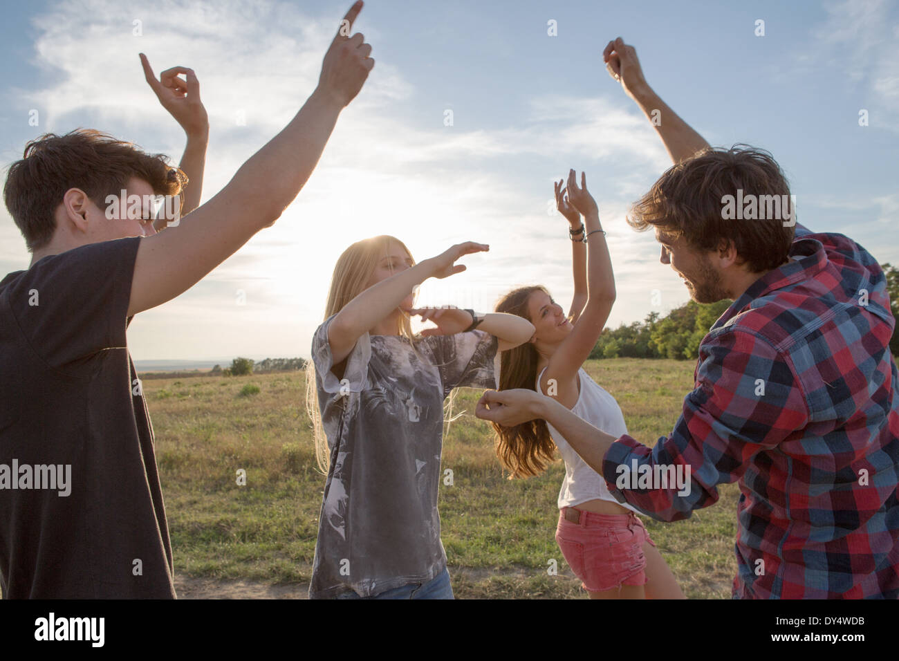 Quattro amici ballare nel campo Foto Stock