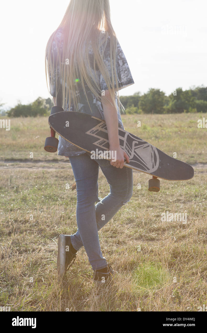 Giovane donna azienda skateboard Foto Stock