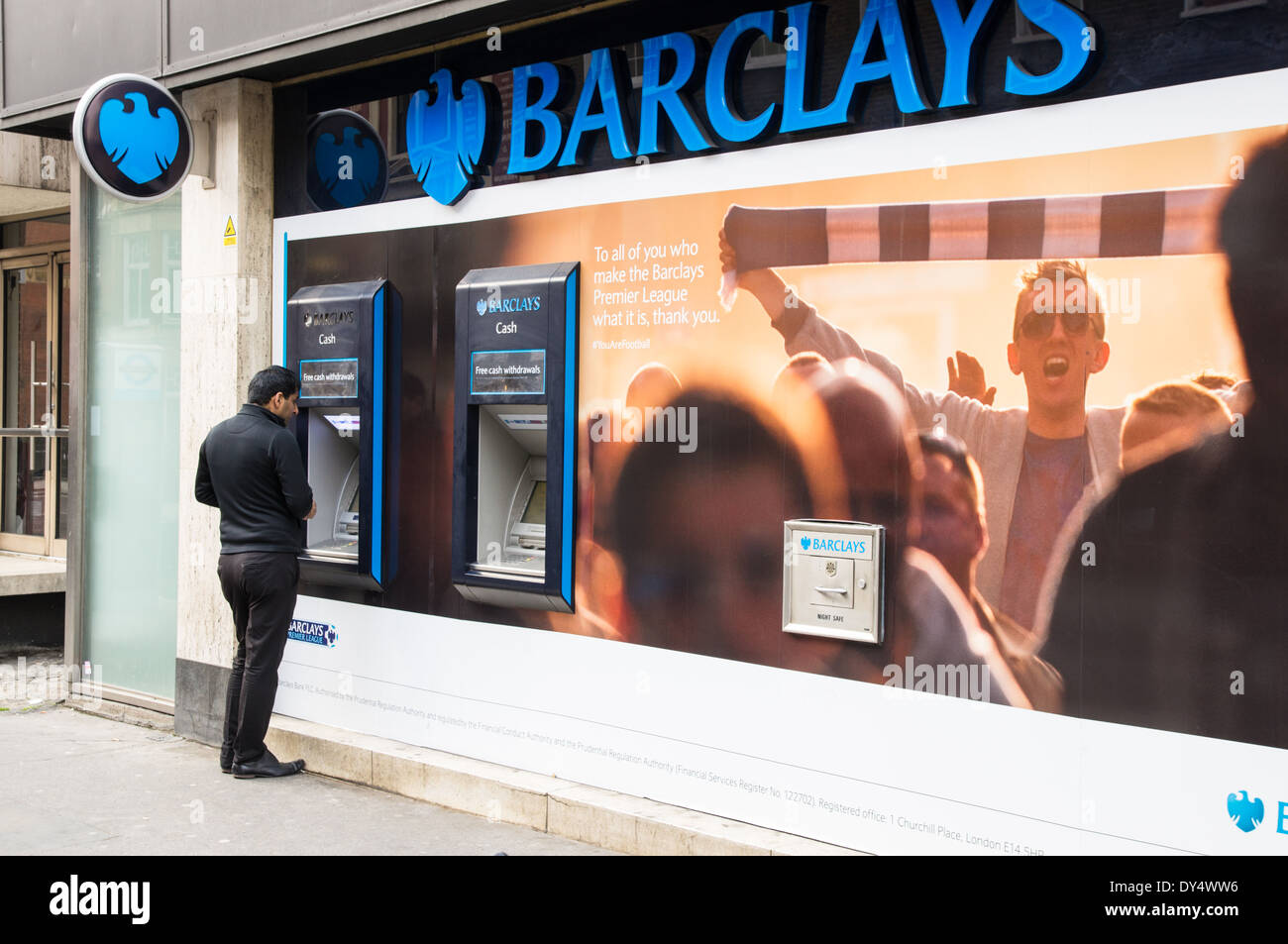 Un uomo di ritirare denaro contante da Barclays bancomat in Londra England Regno Unito Regno Unito Foto Stock
