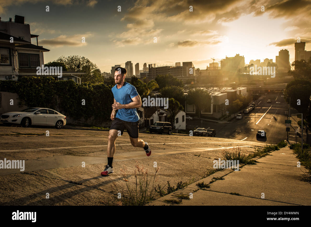 Giovane maschio runner in esecuzione su una ripida collina della città Foto Stock