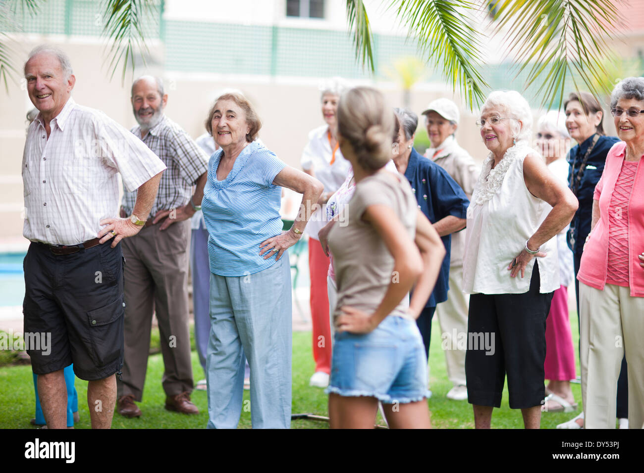 Grande gruppo di anziani che esercitano in pensione villa giardino Foto Stock