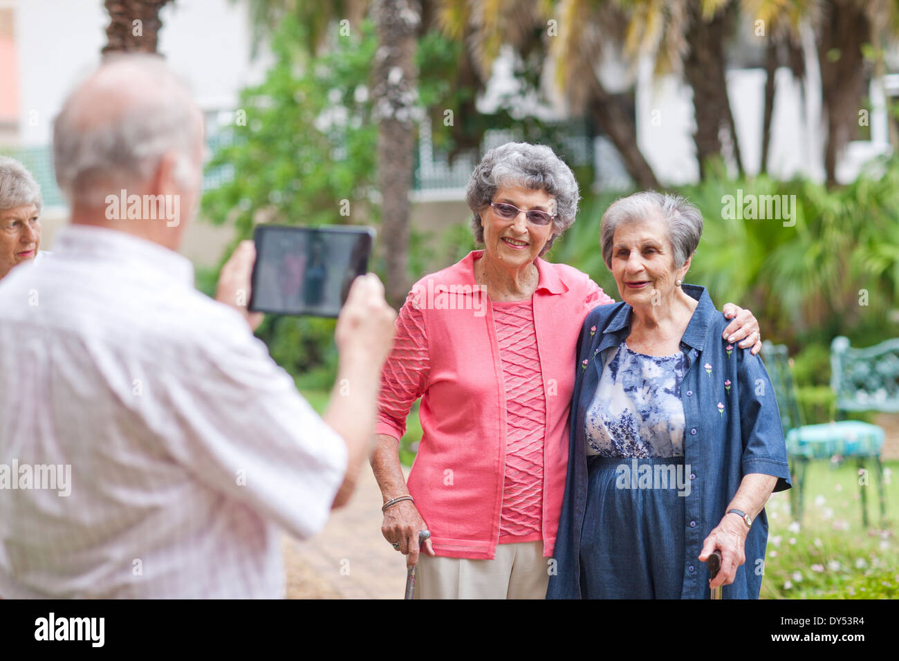 Senior uomo fotografare gli amici in pensione villa giardino Foto Stock